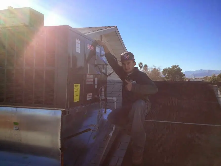 HVAC technician performing AC Tune-Up on a rooftop unit in Wauseon